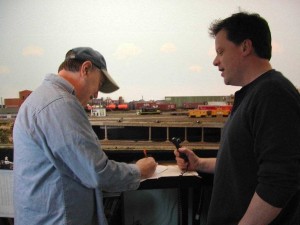 Station agent Greg Arndt issues a clearance form to Mike Davison, conductor of Train #1905