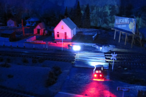 Vehicles with their headlights on at night on Dick Haines layout