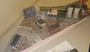Al Carter's diorama is almost complete with the addition of the coal dealer behind the oil storage tanks.