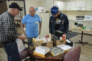 Fig 1 – A Bigger than Usual Swap Meet - Tom Hawkins, Dick Haines and Curt Johnson (l. to r.) Look Over Offerings